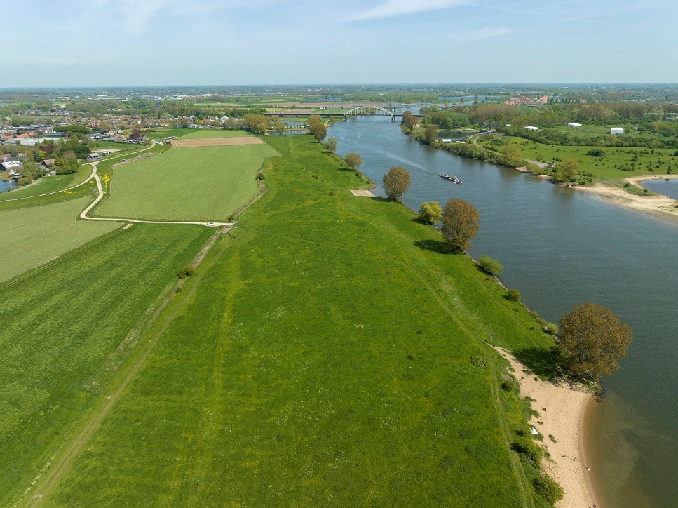Maatregelgebied Oever Benedenwaarden bestaande uit een groot grasland, waarbij Hedel links bovenin ligt en de Maas rechts.